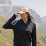 White Sands - Women's Long-Sleeve Hooded Henley in Obsidian (Black), person standing in a mountainous landscape.