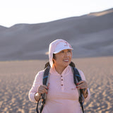 White Sands - Women’s Long-Sleeve Hooded Henley in Prickly Pear (Dusty Pink) (Front view in the sands and backpack) 