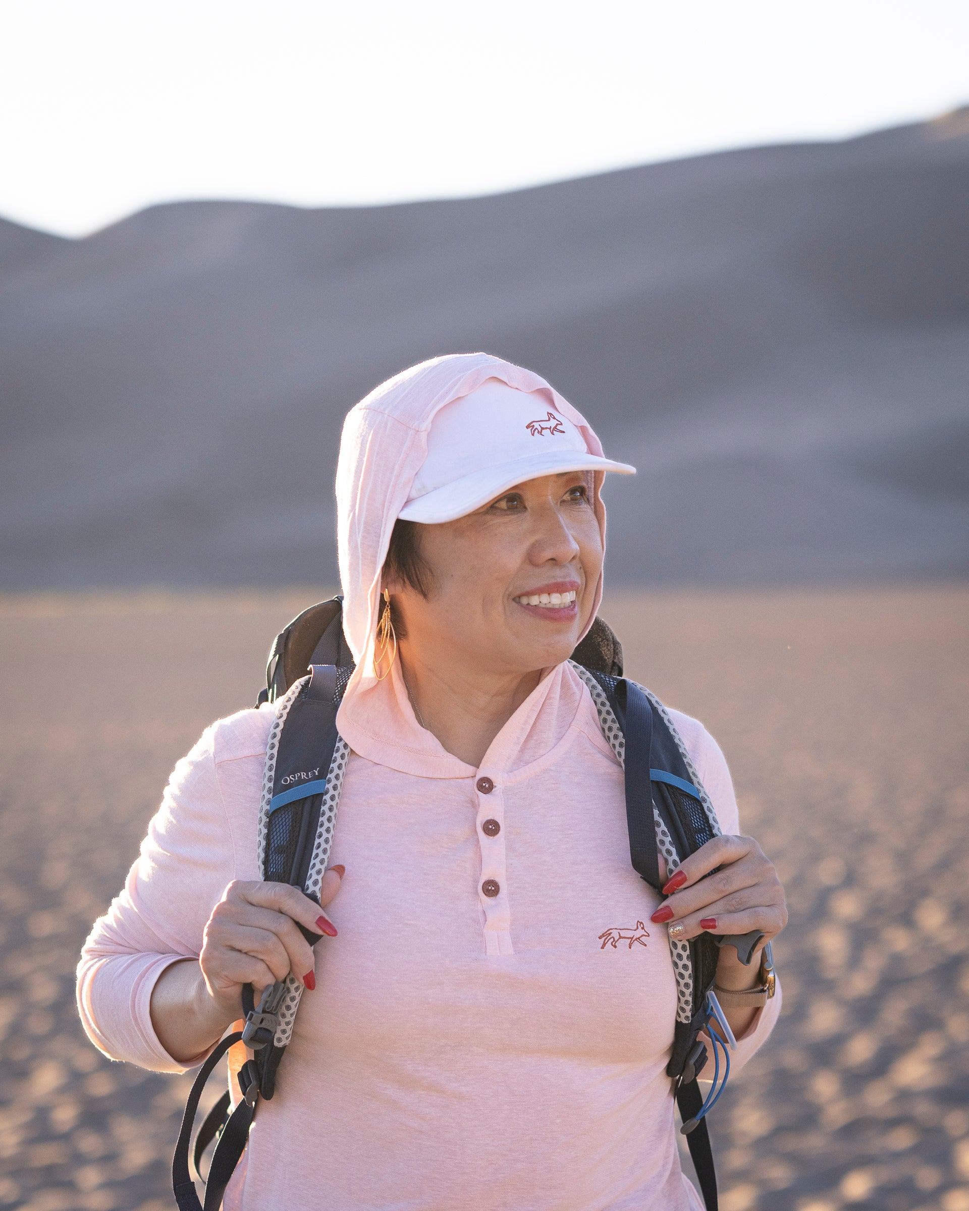 White Sands - Women's Sun Henley with Hideaway Hood, hood up on desert dunes