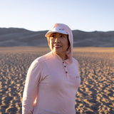 White Sands - Women’s Long-Sleeve Hooded Henley in Prickly Pear (Dusty Pink) (Front view in the sands)