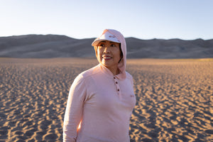 White Sands - Women’s Long-Sleeve Hooded Henley in Prickly Pear (Dusty Pink) (Front view in the sands)