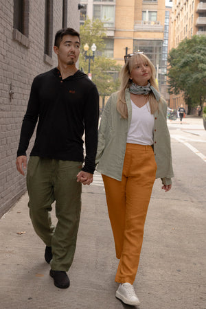 Joshua Tree - Women's Breathable Hemp Trail Pants in Orpiment (Turmeric) and Joshua Tree - Men's Breathable Hemp Trail Pants in Olivine (Green) (front view)