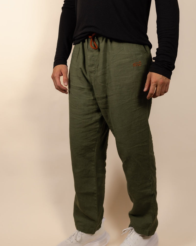 Person wearing green pants with a brand logo on a beige background
